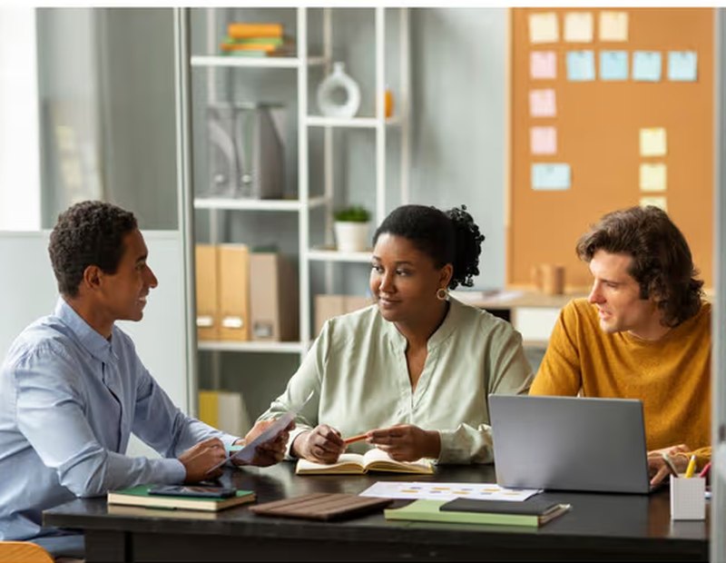 A recruitment team reviewing candidates together around a desk